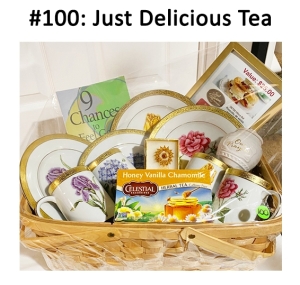 This basket includes a book, serving plates, cups, jar, gift card, tea, and a gold Swarovski crystal sun broach.