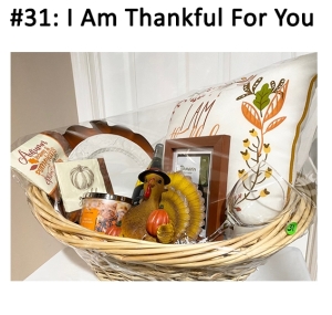 This basket includes a candle, pillow, plate, charger, center piece, napkins, chardonnay, and a wine glass.