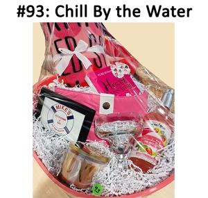 This basket includes a scarf, gift card, margarita mix, margarita glass, candle, hand massager, tote bag, earrings, and a blanket.